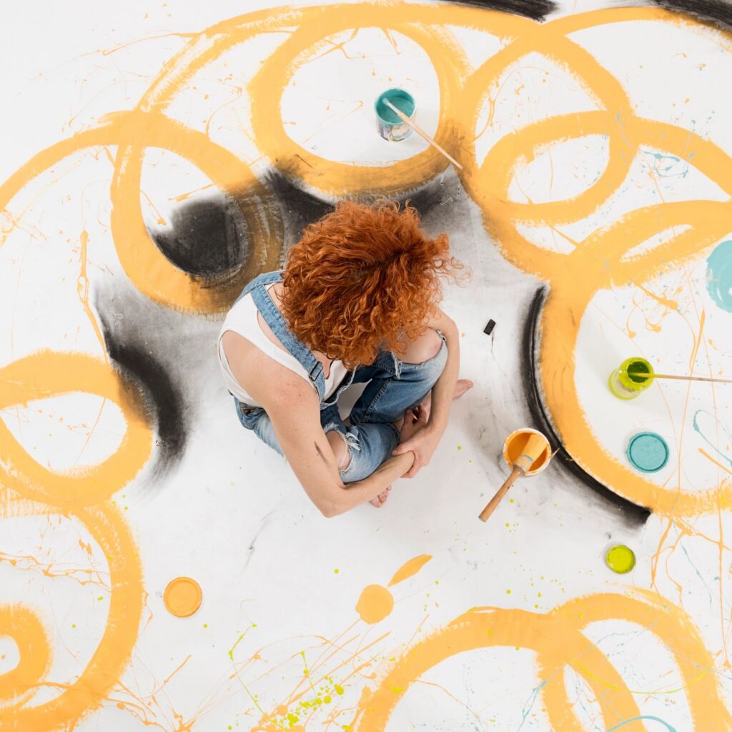 woman artist painting on the floor